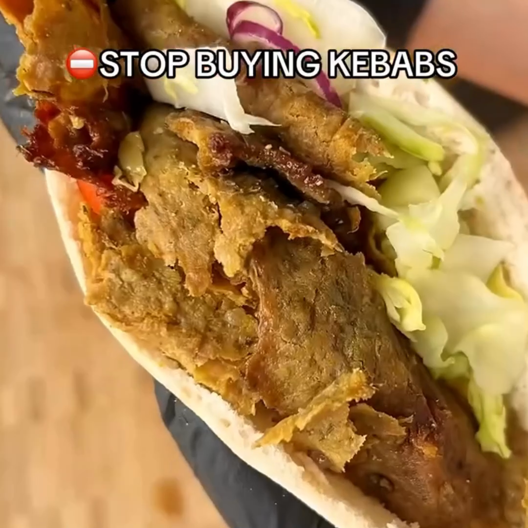 Homemade doner kebab in pita bread with shredded lettuce and sliced red onion